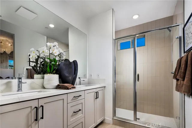 a bathroom with a double vanity sink and shower