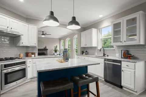 a kitchen with cabinets stainless steel appliances a sink and a stove