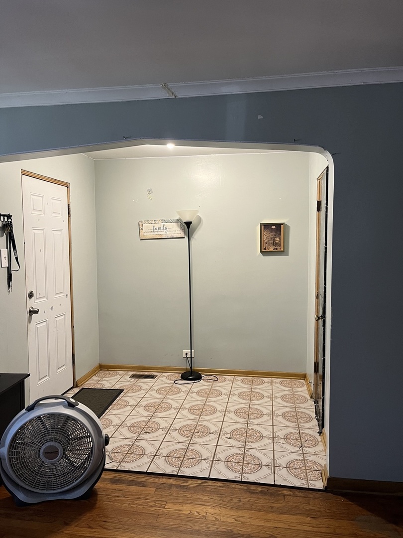 11437 South Calumet Avenue Chicago, IL 60628 - Photo 11 of 11 a bedroom with a bed and a wooden floor