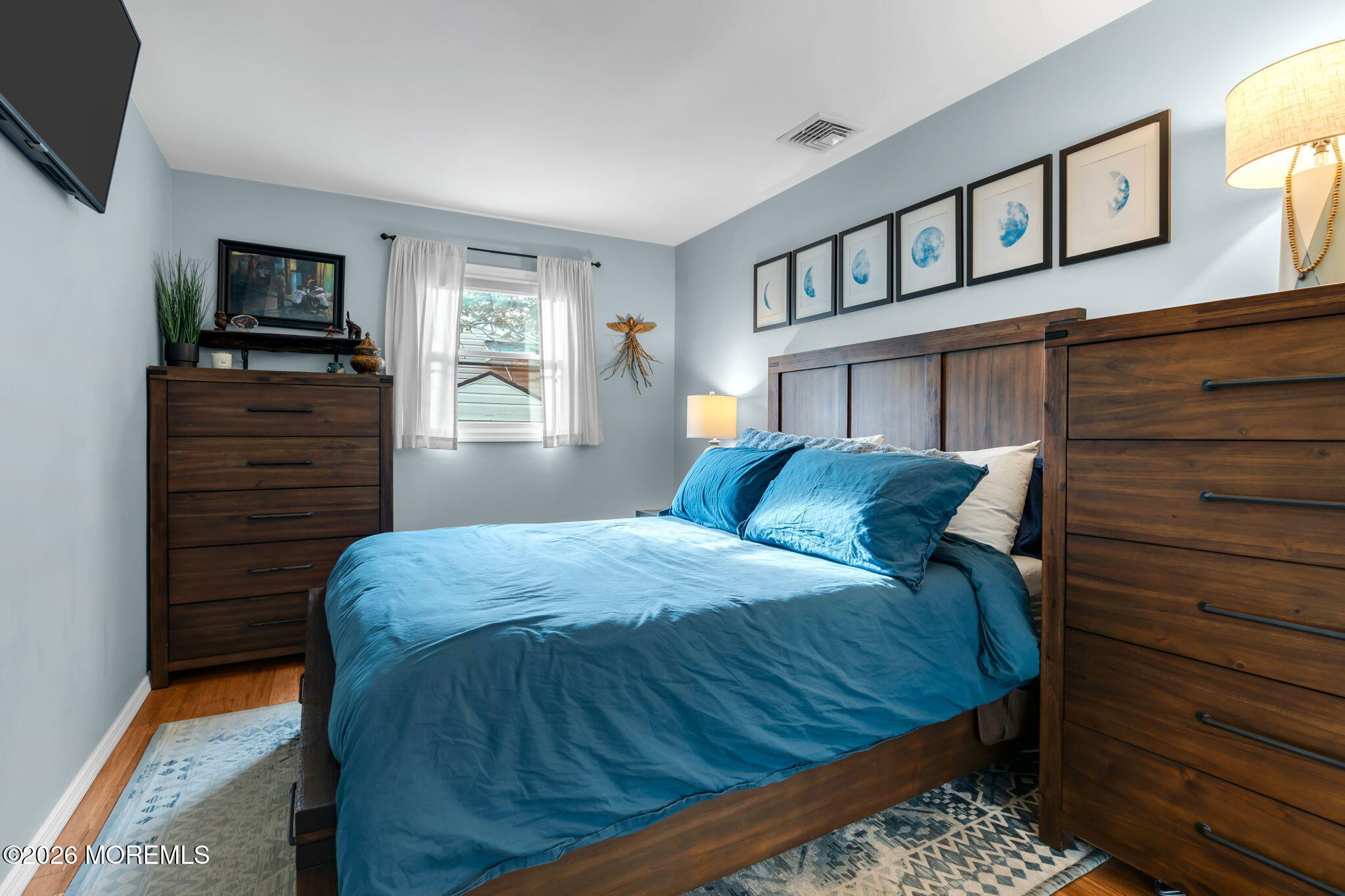 51 7th Street Belford, NJ 07718 - Photo 16 of 26 a bedroom with a bed a mirror on dresser and a flat screen tv