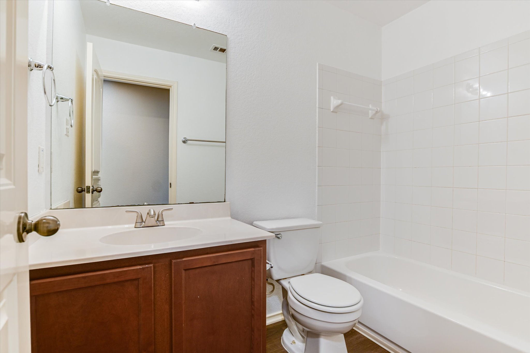 2864 Hearthsong Loop Round Rock, TX 78665 - Photo 16 of 29 Bathroom with vanity, bathing tub / shower combination, and dark wood-style flooring