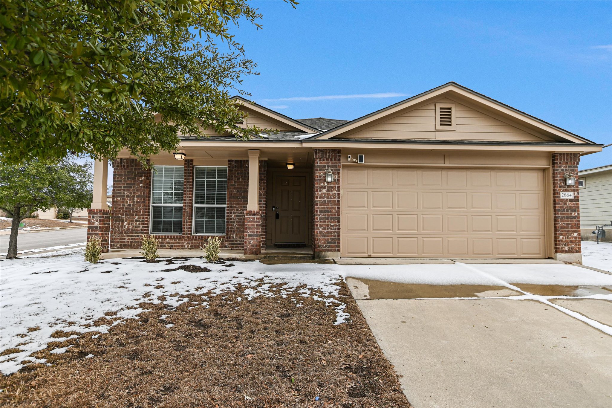2864 Hearthsong Loop Round Rock, TX 78665 - Photo 2 of 29 Ranch-style house with driveway, brick siding, an attached garage, and a porch