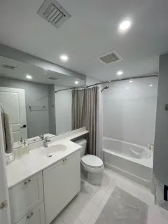 a bathroom with a double vanity sink toilet and shower