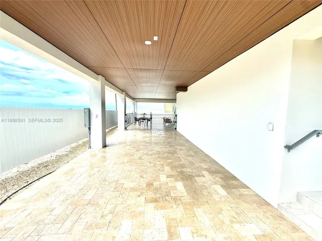 a living room with patio furniture and a floor to ceiling window