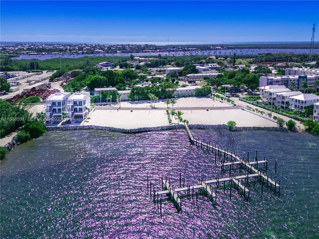 a view of multiple houses with a yard and plants
