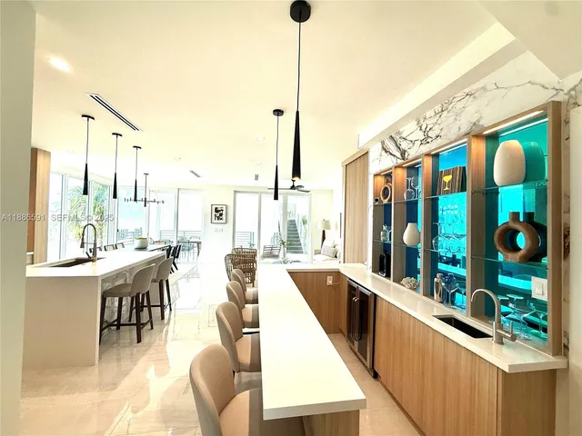 a very nice looking dining room with a large window and kitchen view