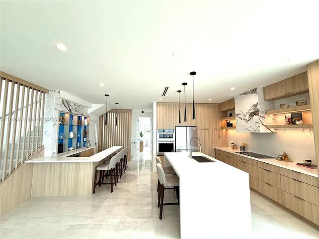 a kitchen with kitchen island a stove a table and chairs in it