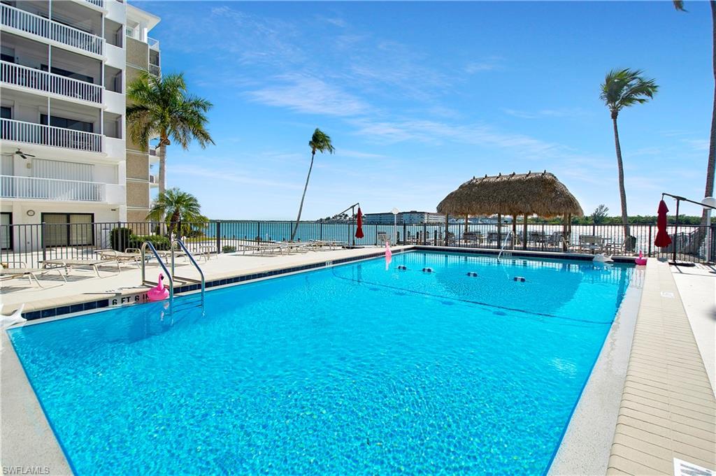 60 West Pelican Street, Unit 505 Naples, FL 34113 - Photo 23 of 41 a view of swimming pool with a table and chairs
