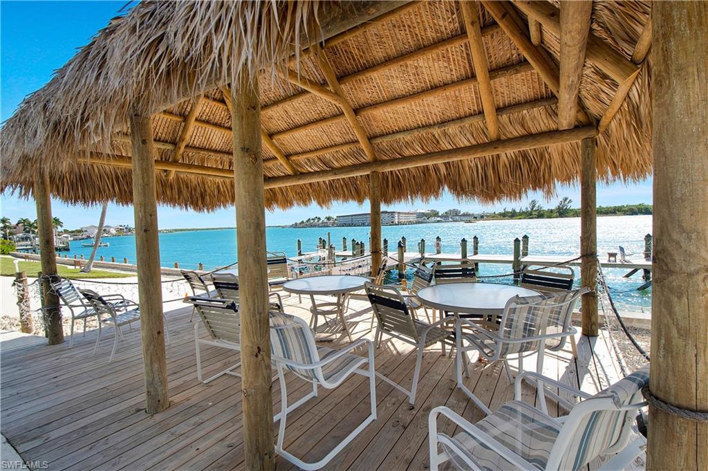 60 West Pelican Street, Unit 505 Naples, FL 34113 - Photo 26 of 41 a view of a patio with table and chairs under an umbrella with wooden floor