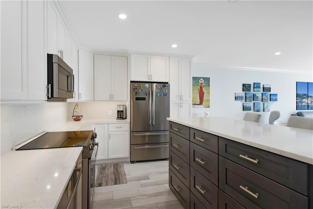 60 West Pelican Street, Unit 505 Naples, FL 34113 - Photo 7 of 41 a kitchen with stainless steel appliances a refrigerator sink and microwave