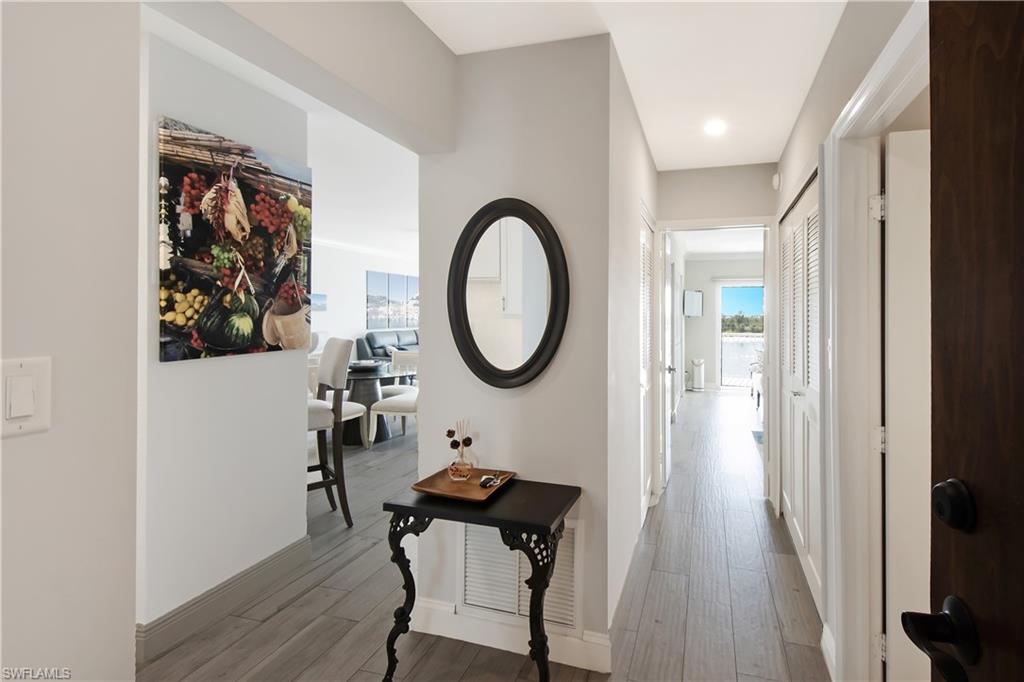 60 West Pelican Street, Unit 505 Naples, FL 34113 - Photo 10 of 41 a very nice looking room with a mirror and a wooden floor