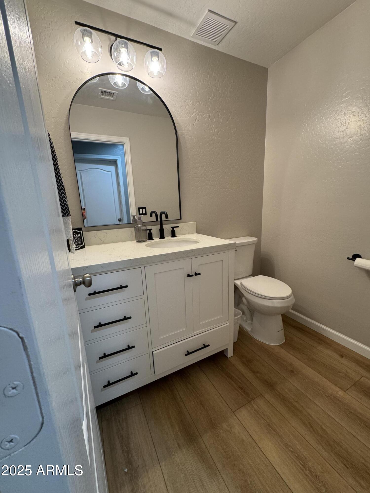 13781 West Vernon Avenue Goodyear, AZ 85395 - Photo 17 of 25 a bathroom with a toilet sink and mirror