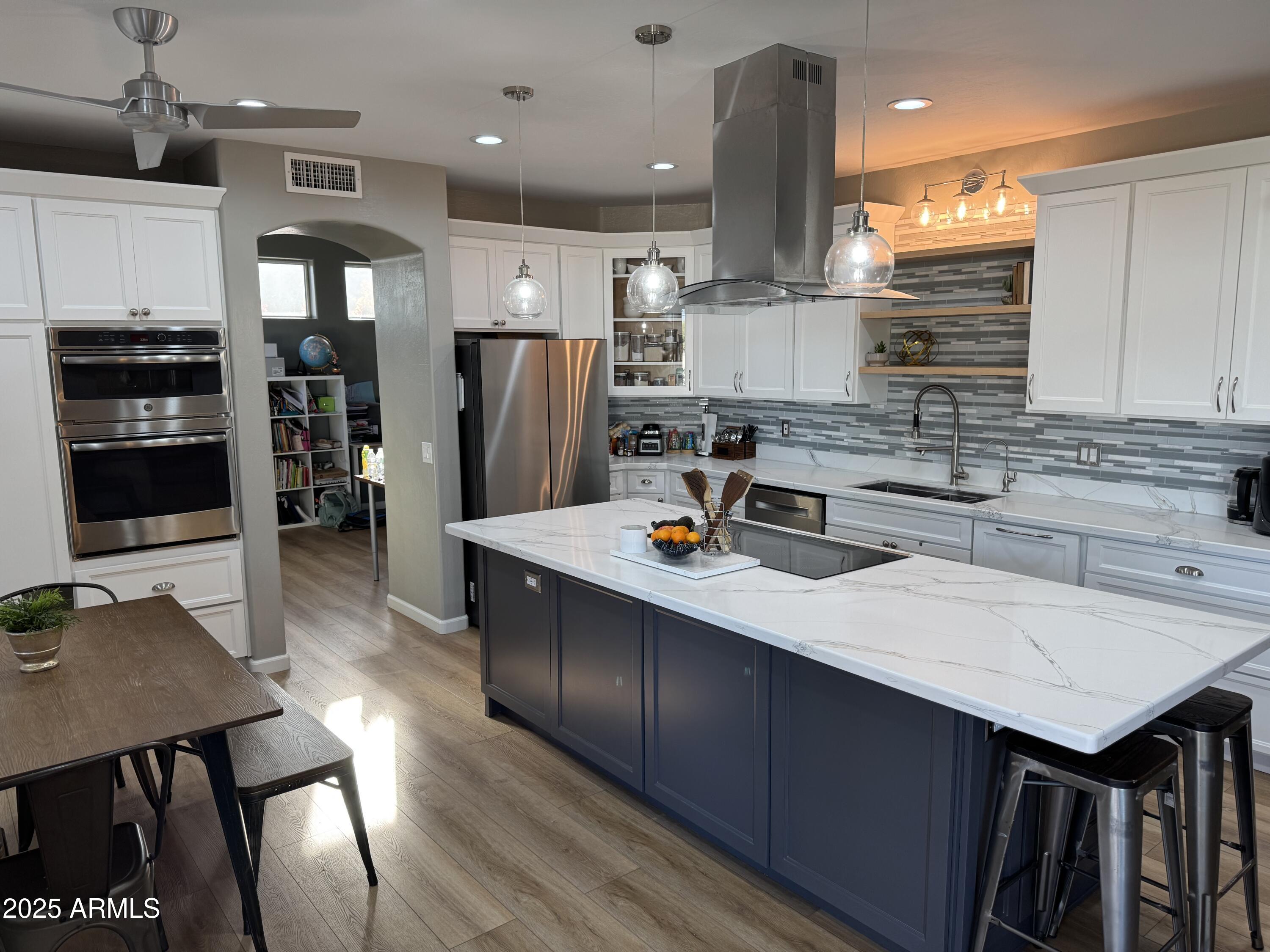 13781 West Vernon Avenue Goodyear, AZ 85395 - Photo 20 of 25 a kitchen with stainless steel appliances granite countertop a stove refrigerator sink and cabinets