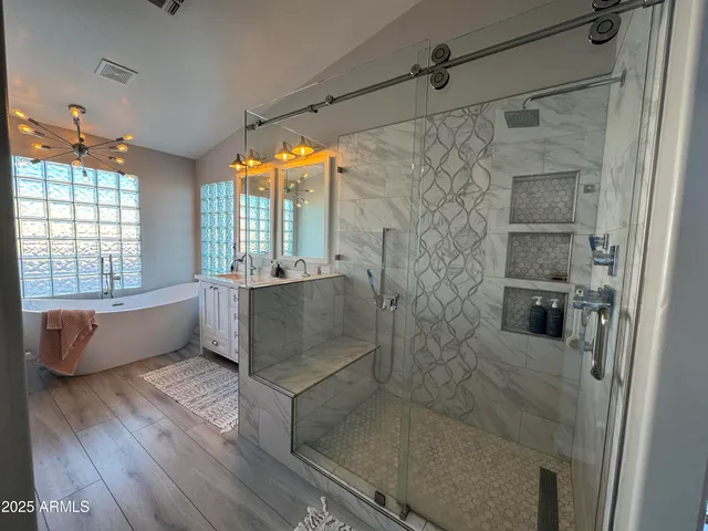 a bathroom with a tub shower and window