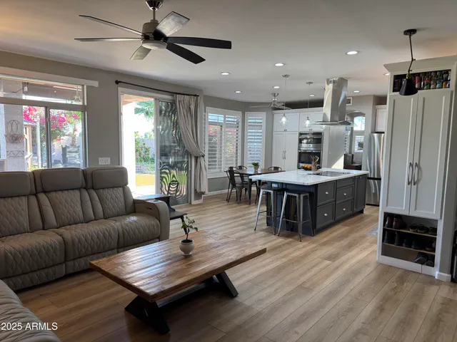 a living room with furniture a ceiling fan and a window