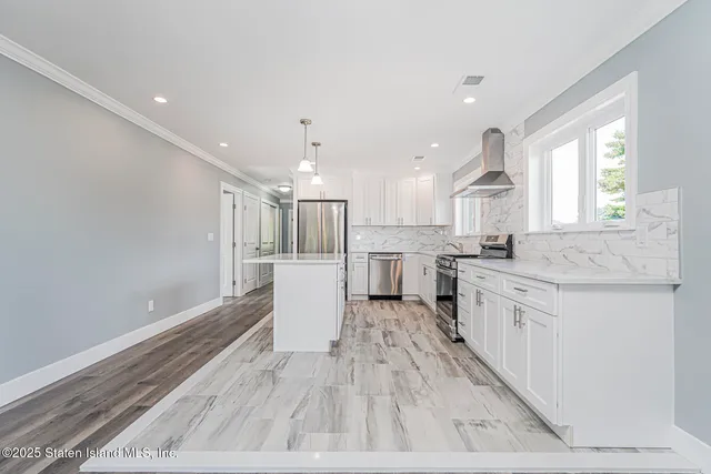 a open kitchen with white cabinets and wooden floor
