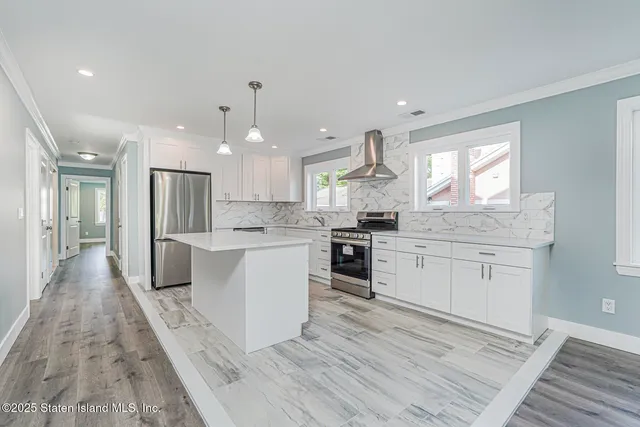 a large kitchen with granite countertop a large counter top space a sink stainless steel appliances and cabinets