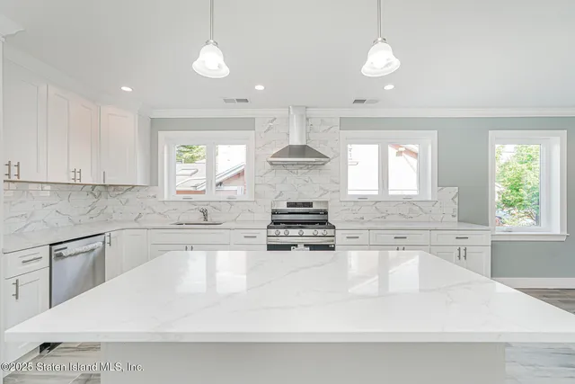 a large kitchen with a stove and white cabinets
