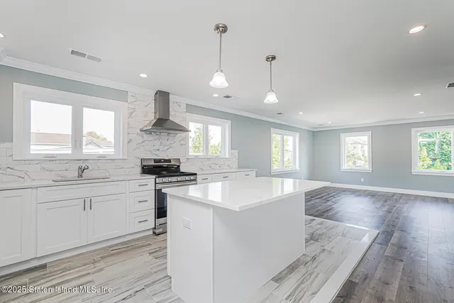 an open kitchen with a sink stove and wooden floor