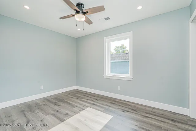 an empty room with a window and a ceiling fan