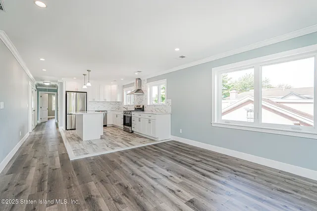 a view of a kitchen with wooden floor and a window
