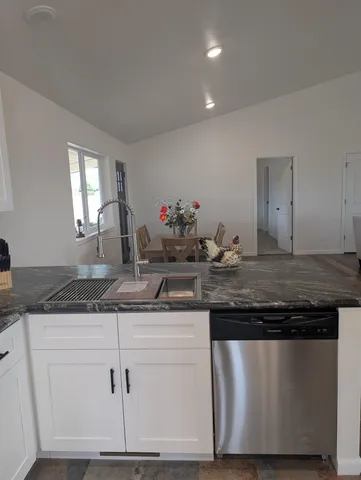 a kitchen with granite countertop a sink and cabinets
