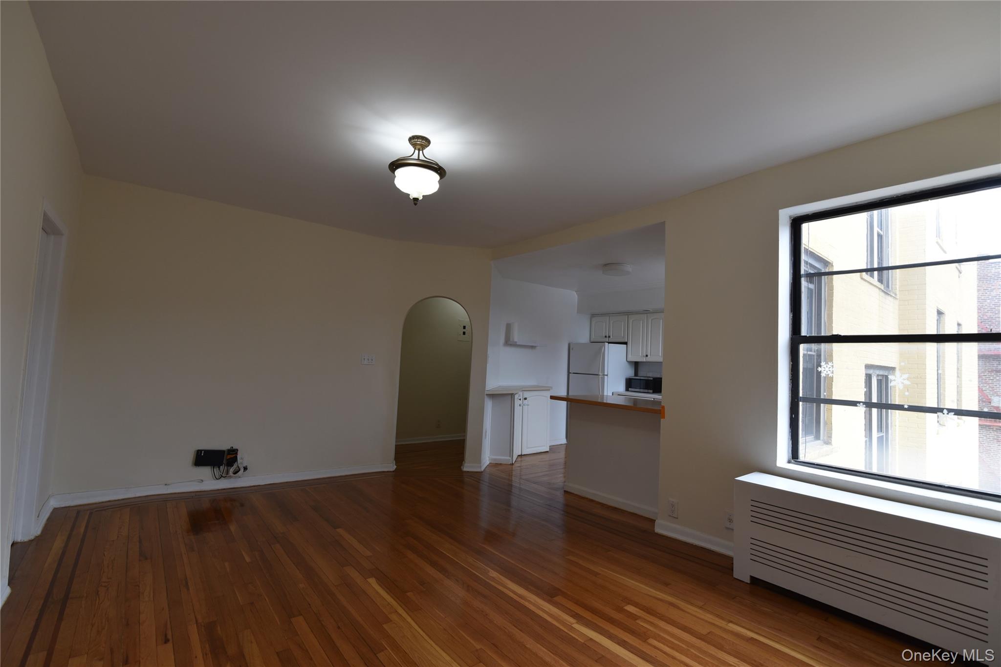 83-52 Talbot Street, Unit 5C Queens, NY 11415 - Photo 13 of 22 a view of empty room with wooden floor and fan