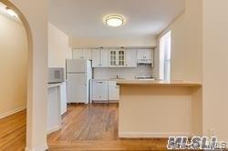 83-52 Talbot Street, Unit 5C Queens, NY 11415 - Photo 6 of 22 a view of kitchen with cabinets and wooden floor