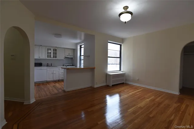 a kitchen with kitchen island granite countertop wooden floors and white cabinets