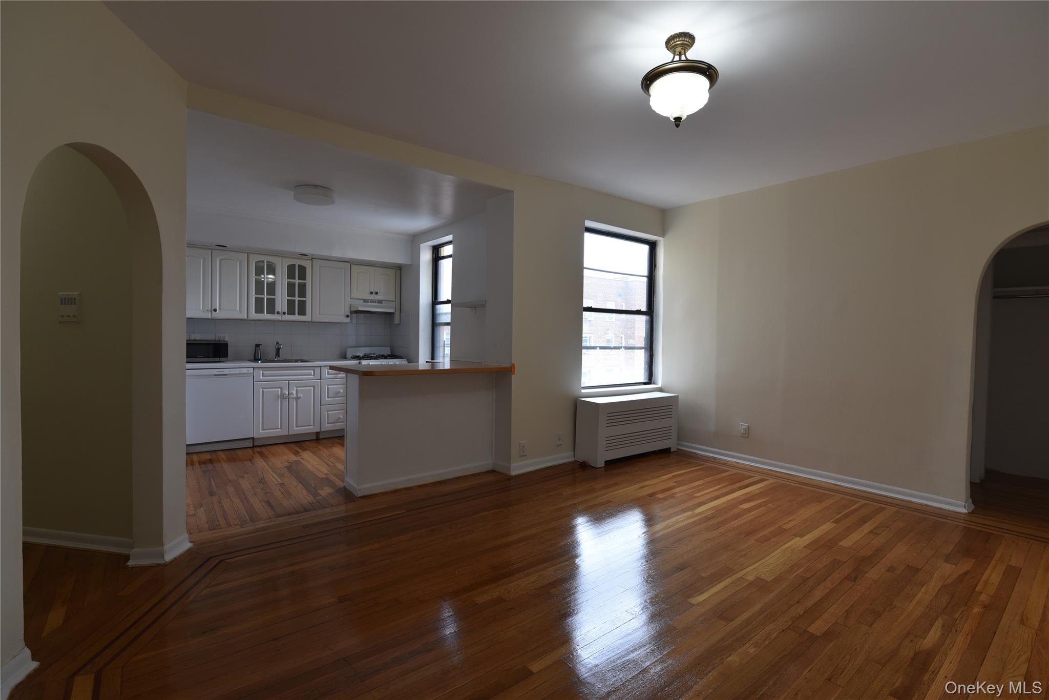 83-52 Talbot Street, Unit 5C Queens, NY 11415 - Photo 10 of 22 an empty room with wooden floor and windows