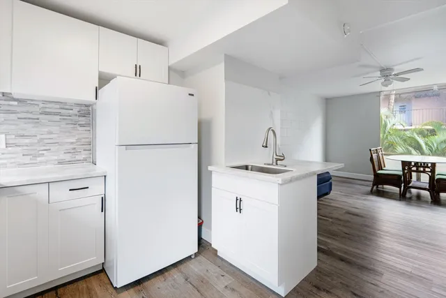 a kitchen with a refrigerator sink and chairs