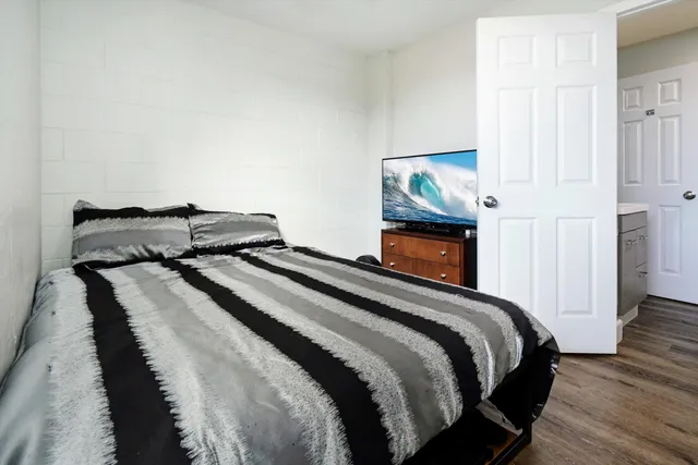 a bedroom with bed and wooden floor