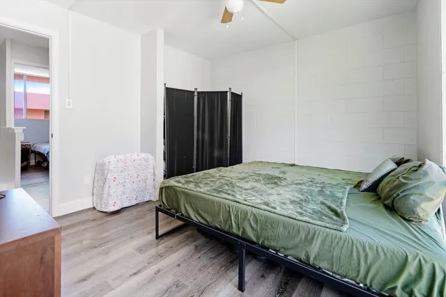 a bedroom with a bed and wooden floor