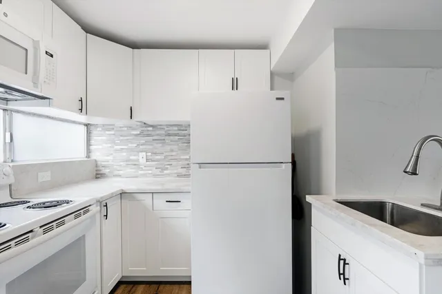 a kitchen with a refrigerator sink stove and cabinets