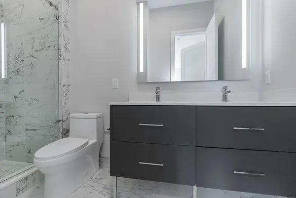 a bathroom with a toilet a sink a mirror and vanity