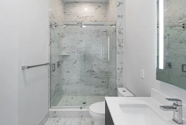 a bathroom with a bathtub shower sink vanity and toilet