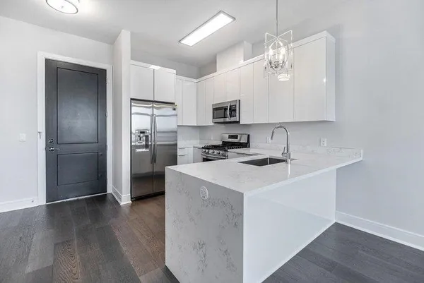 a kitchen with kitchen island a refrigerator stove and sink