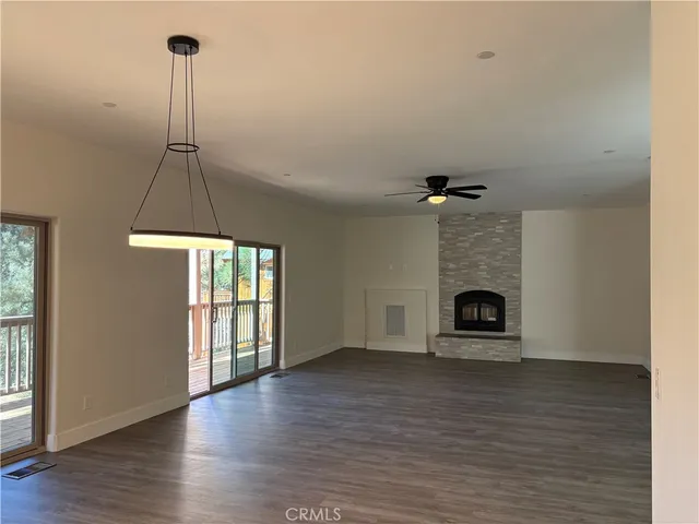 a view of empty room with a fireplace and wooden floor