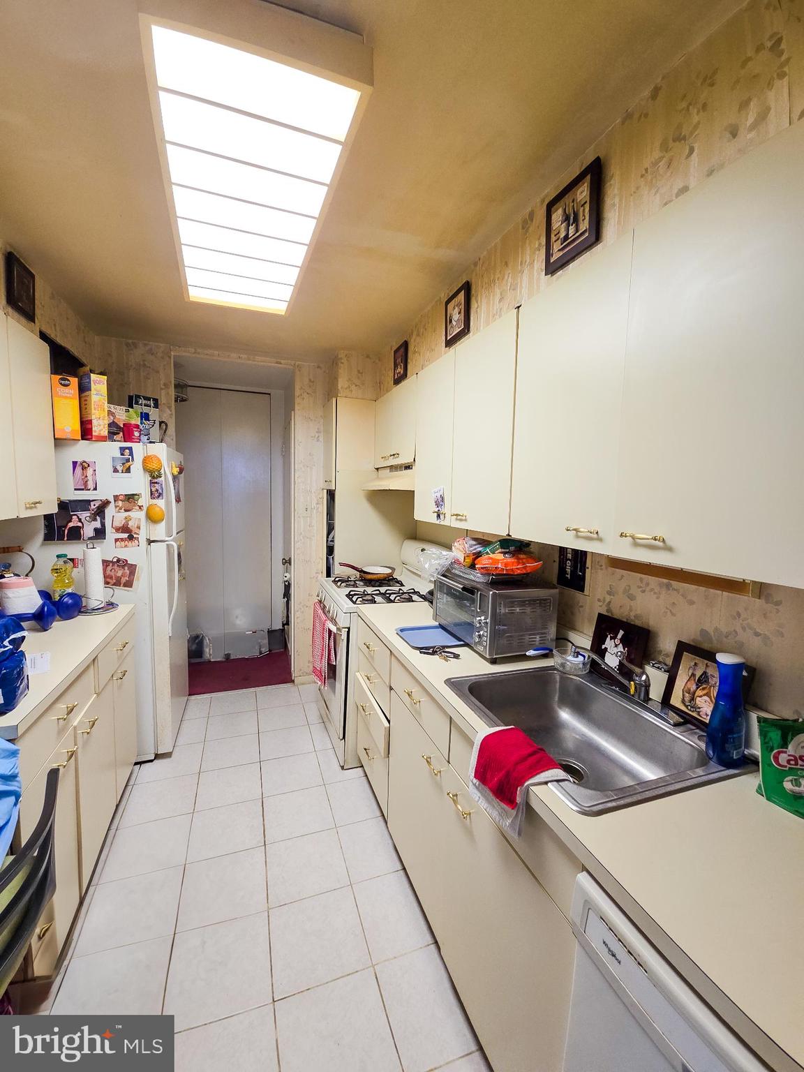 3600 Conshohocken Avenue, Unit 1804 Philadelphia, PA 19131 - Photo 3 of 10 a kitchen with a sink dishwasher and a stove top oven