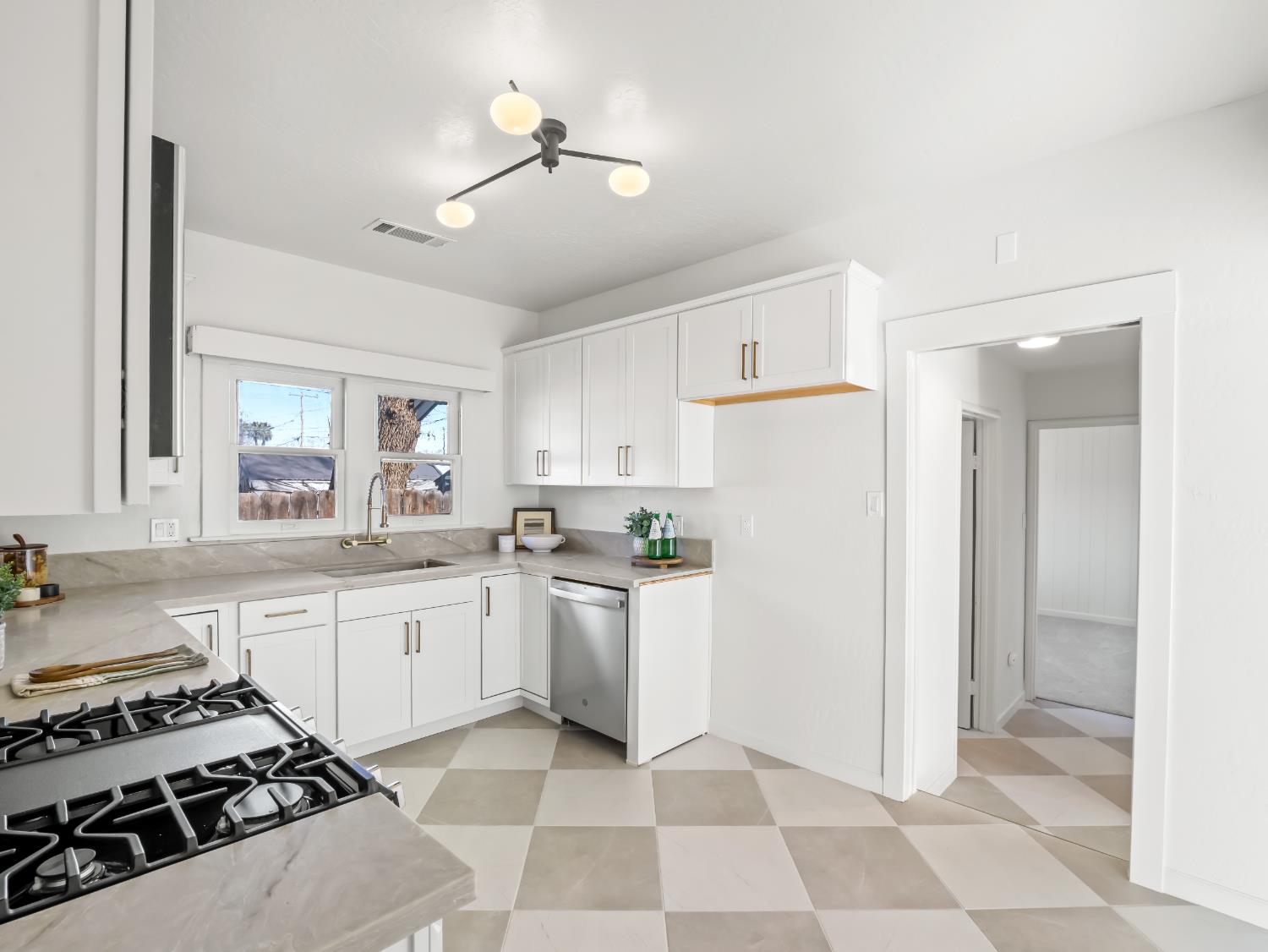 425 West Elm Street Hanford, CA 93230 - Photo 7 of 18 a kitchen with a stove a sink and a refrigerator