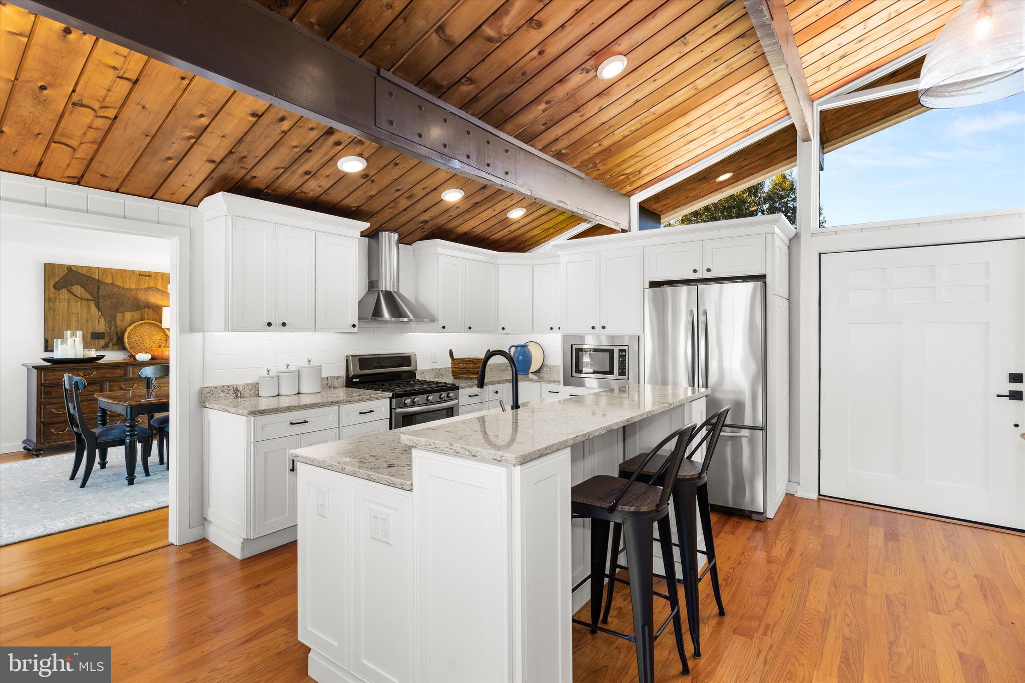 61 Grand Port Road Ocean Pines, MD 21811 - Photo 29 of 68 a kitchen with stainless steel appliances granite countertop a table chairs and wooden floors