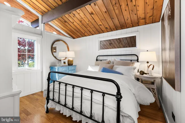 a bedroom with a bed wooden floor and window