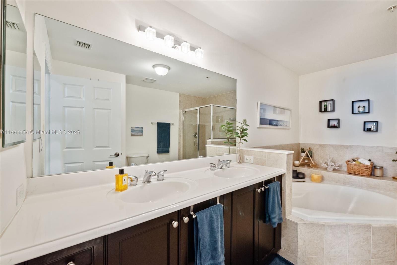 8390 Southwest 72nd Avenue, Unit 314 Miami, FL 33143 - Photo 16 of 35 a bathroom with a sink double vanity and a bathtub