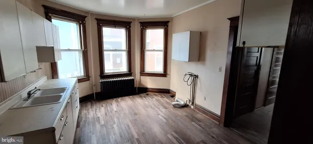 a view of a living room with a large window and wooden floor