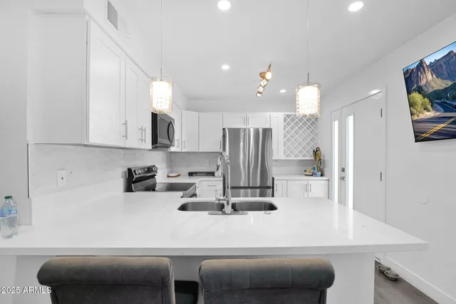 a kitchen with a table chairs refrigerator and microwave