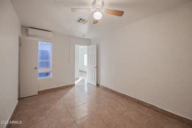 an empty room with fan and windows