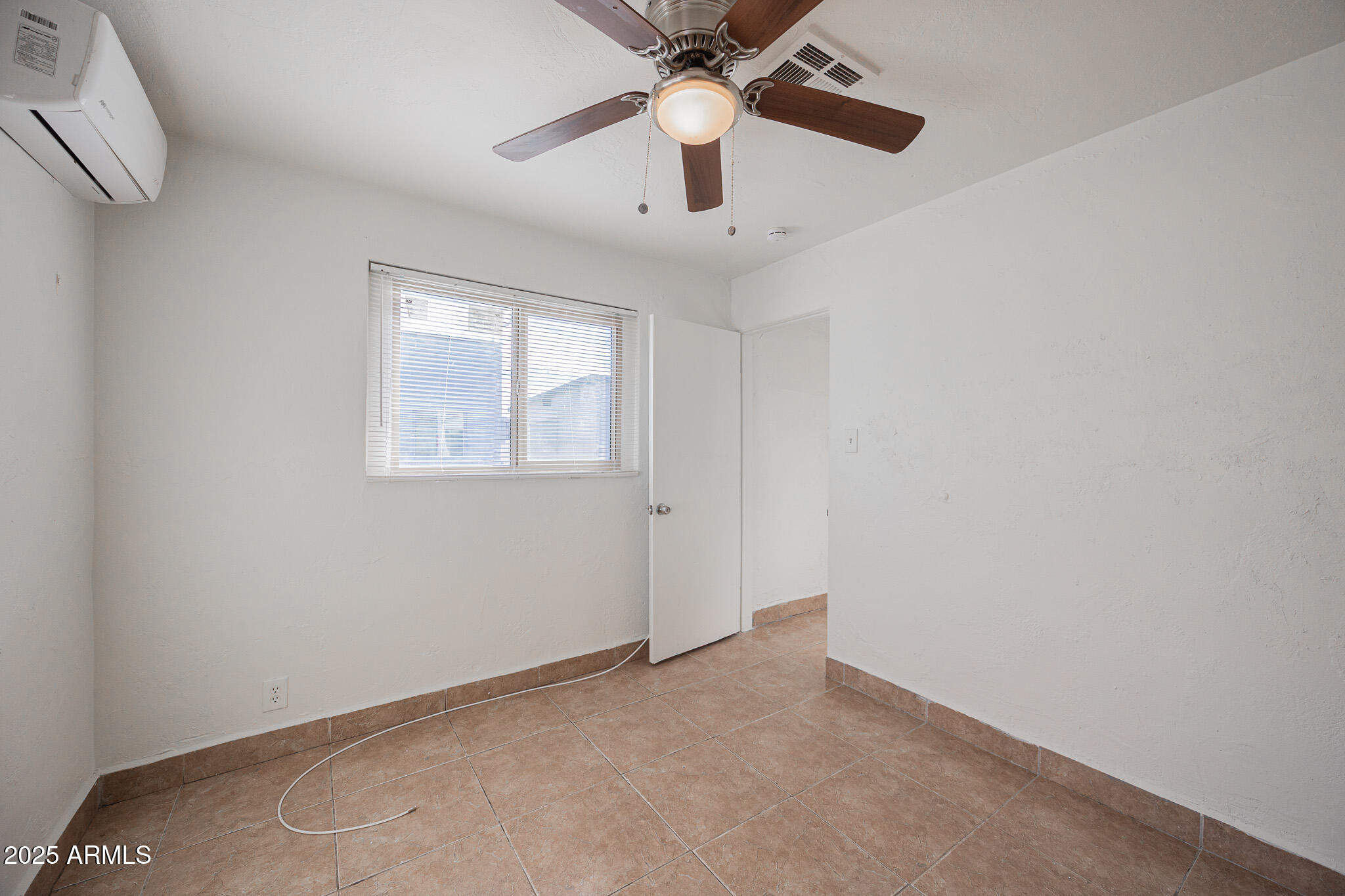 2537 East Willetta Street, Unit 4 Phoenix, AZ 85008 - Photo 9 of 15 an empty room with a chandelier fan and windows