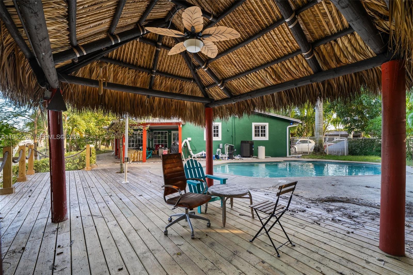 5741 Southwest 14th Street Plantation, FL 33317 - Photo 7 of 29 a view of a patio with table and chairs under an umbrella with wooden floor