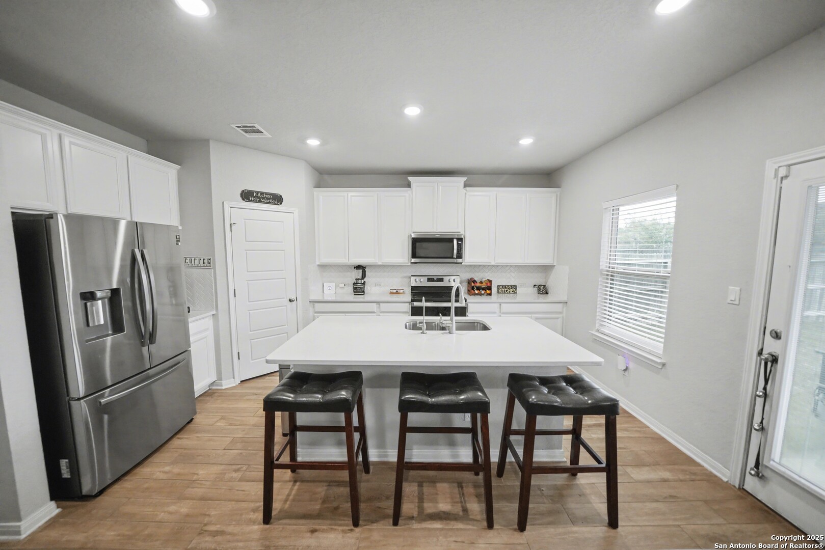 3083 Mondavi Crest Schertz, TX 78154 - Photo 15 of 47 a kitchen with stainless steel appliances a refrigerator a stove a sink dishwasher a dining table and chairs with wooden floor