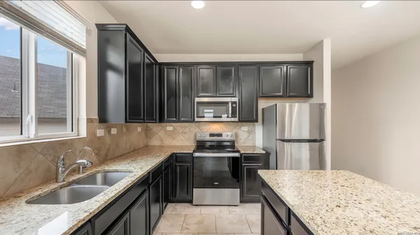 a kitchen with kitchen island a sink stove and refrigerator
